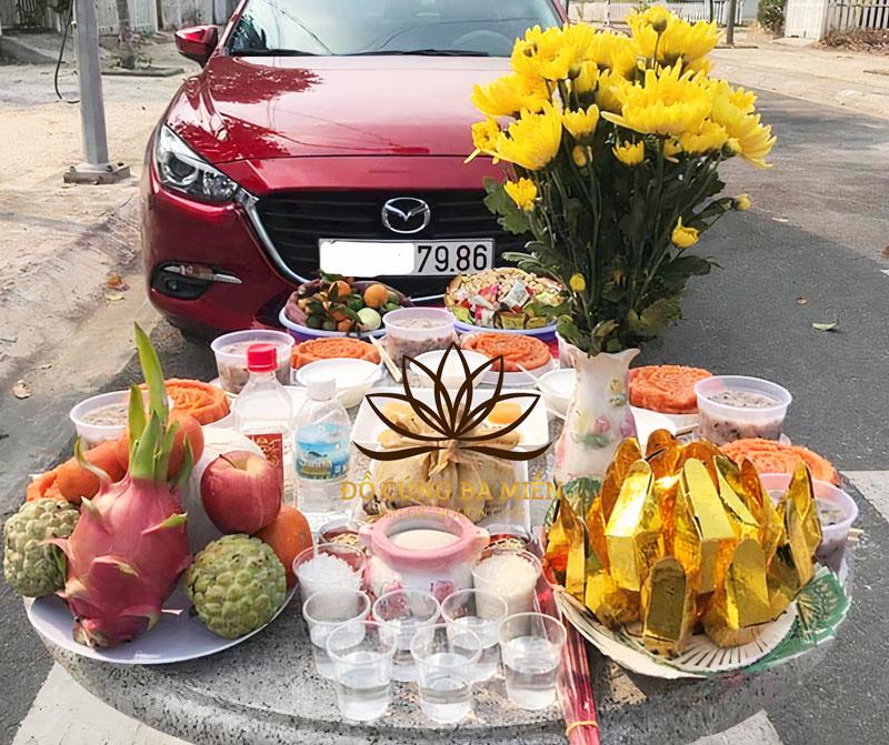 Người chủ xe đang làm lễ nhập trạch cho chiếc xe mới với hương hoa quả trên bàn cúng